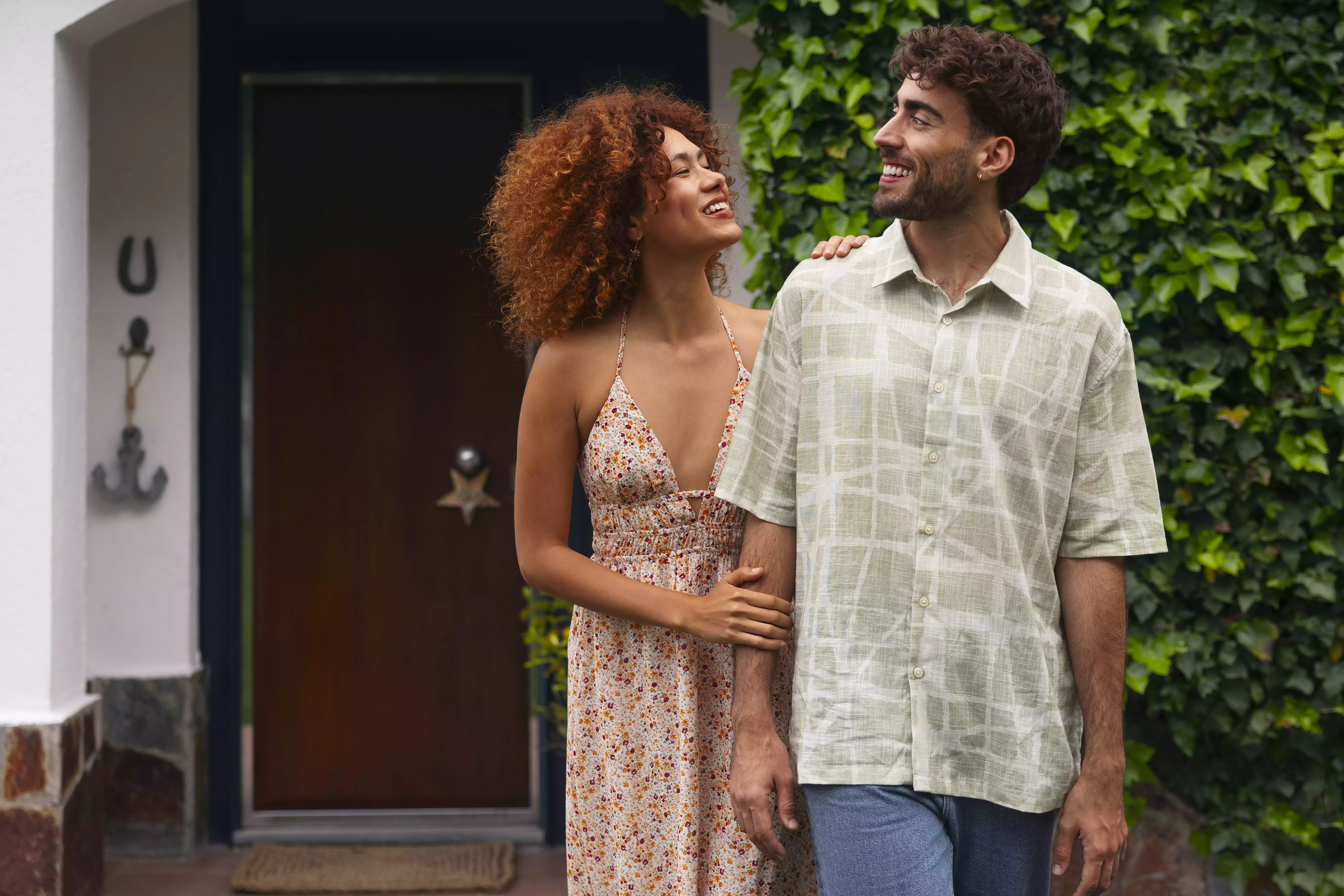 Couple posing in front of their new home